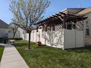 View of yard featuring a pergola and fence