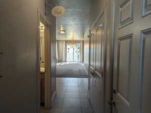 Hallway featuring a textured ceiling and carpet