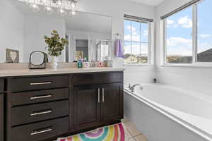 Bathroom featuring vanity, a bathing tub, and tile patterned floors