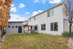 Back of property featuring an outdoor living space, a lawn, and a gazebo