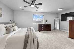 Carpeted bedroom featuring a textured ceiling and ceiling fan