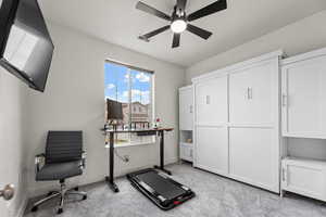 Exercise area featuring ceiling fan and light colored carpet