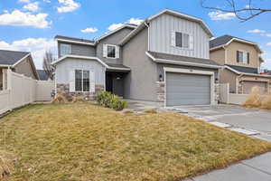 View of front facade featuring a front yard and a garage