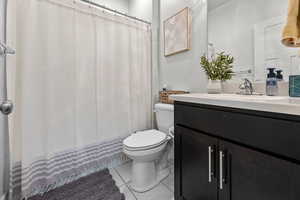 Bathroom featuring tile patterned floors, toilet, and vanity