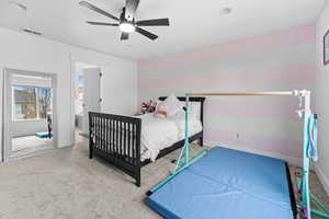 Carpeted bedroom with ceiling fan