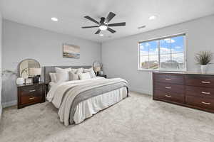 Carpeted bedroom featuring ceiling fan