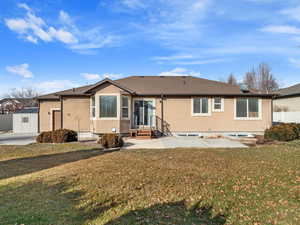 Back of property featuring a yard and a storage shed