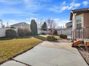 View of yard with a patio area and a storage shed