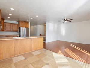 Kitchen featuring sink, ceiling fan, light hardwood / wood-style floors, and stainless steel appliances