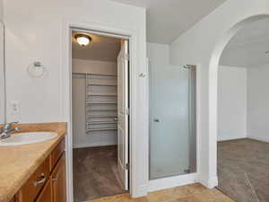 Bathroom featuring vanity and a shower with door