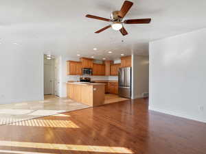 Kitchen featuring light hardwood / wood-style flooring, stainless steel appliances, ceiling fan, sink, and kitchen peninsula