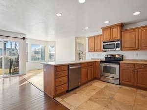 Kitchen featuring sink, kitchen peninsula, a textured ceiling, and stainless steel appliances