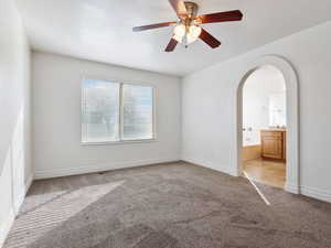 Carpeted spare room featuring ceiling fan