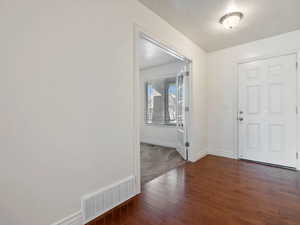 Entrance foyer with dark hardwood / wood-style floors