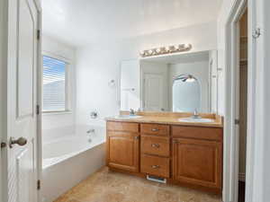 Bathroom featuring vanity and a relaxing tiled tub