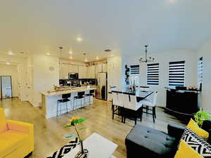 Living room with light hardwood / wood-style flooring and a chandelier
