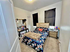 Carpeted bedroom with a textured ceiling