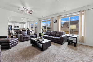 Carpeted living room with ceiling fan