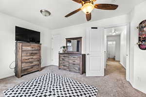 Bedroom with ceiling fan and light carpet