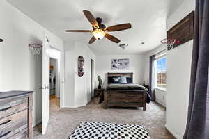 Bedroom featuring light carpet, ceiling fan, and washer / dryer