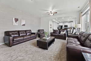 Carpeted living room with ceiling fan