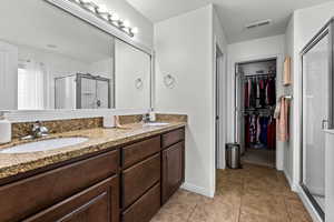 Bathroom with vanity, an enclosed shower, and tile patterned flooring