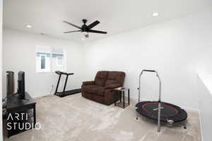 Workout room with light colored carpet and ceiling fan