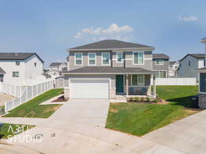 View of front of house with a front yard, a garage, and a porch