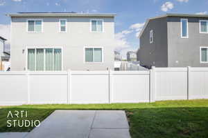 Back of house with a patio and a lawn