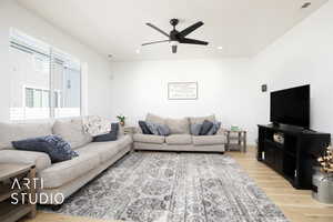 Living room featuring ceiling fan and wood-type flooring