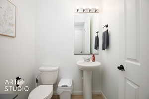 Bathroom featuring sink, toilet, and hardwood / wood-style flooring