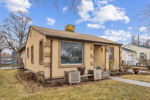 View of front of house featuring a front yard and central AC unit