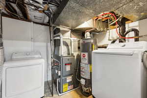 Utilities featuring gas water heater, separate washer and dryer, and heating unit