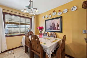 Dining room with an inviting chandelier and light tile patterned floors