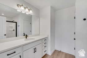 Bathroom featuring wood-type flooring, an enclosed shower, and vanity