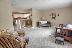 Living room with a textured ceiling and light colored carpet