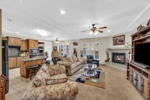 Living room featuring a high end fireplace, ceiling fan, and light tile patterned floors