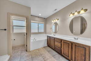 Full bath with recessed lighting, double vanity, a sink, visible vents, and a garden tub