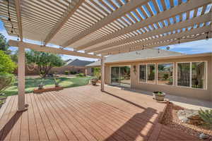 Wooden terrace featuring a fenced backyard, a pergola, and a lawn