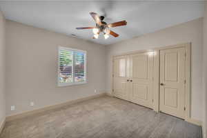 Unfurnished bedroom with carpet, visible vents, a closet, and baseboards
