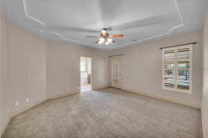 Empty room featuring a ceiling fan, carpet flooring, baseboards, and plenty of natural light