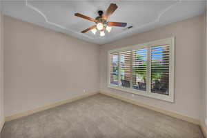 Spare room featuring a ceiling fan, visible vents, carpet, and baseboards