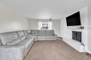 Unfurnished living room featuring light carpet and a fireplace