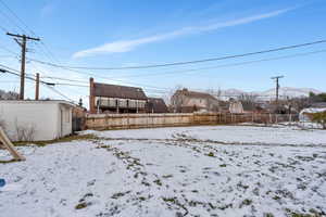 Yard covered in snow featuring a mountain view