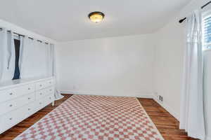 Unfurnished bedroom with wood-type flooring