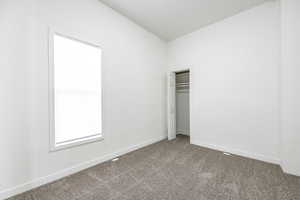 Unfurnished bedroom with carpet and a closet