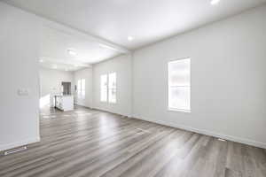 Unfurnished living room featuring sink and light hardwood / wood-style floors