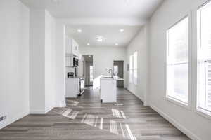 Kitchen with a center island with sink, appliances with stainless steel finishes, sink, a kitchen breakfast bar, and white cabinets