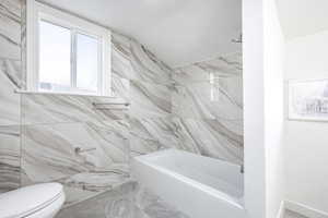 Bathroom with tile walls and toilet