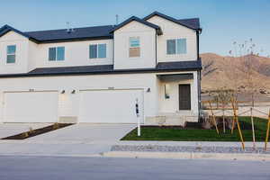 View of front facade with a garage and a mountain view